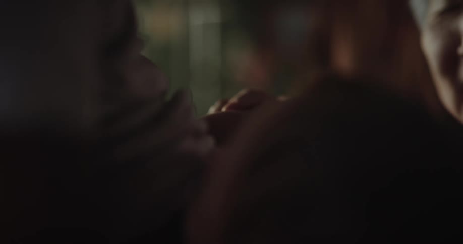 A grandmother happily plays with a babys hand in her hand while smiling and having fun
