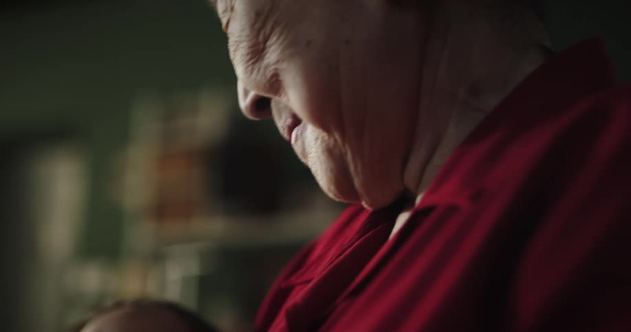 A grandmother is holding a sleeping child