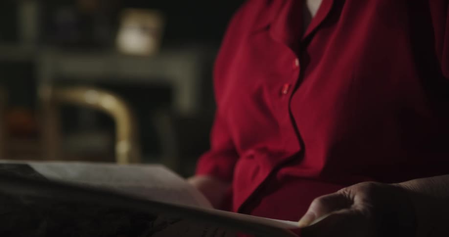 An elderly woman is reading a book