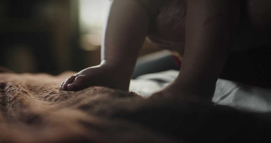 Closeup of a babys feet under a brown rug