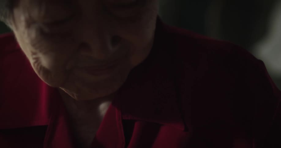 A grandmother caressing her sleeping grandson
