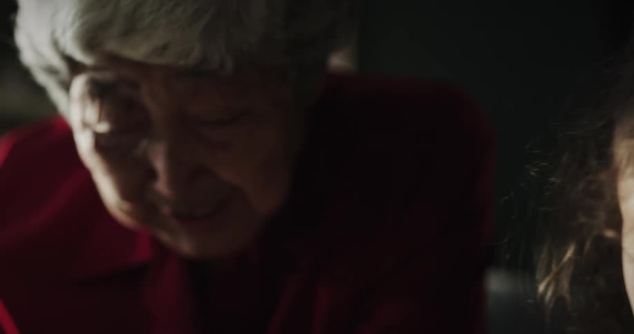 Grandmother talks as granddaughter pays close attention and nods