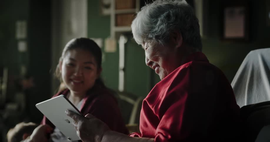 A clip of an elderly woman showing a young lady a content on her device