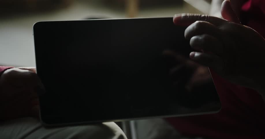 Closeup of a tablet with two hands swiping