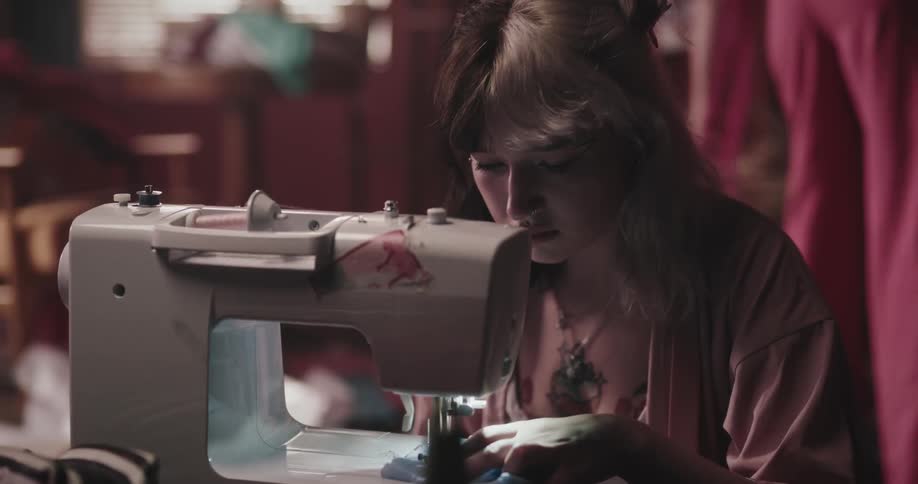 A female is sewing a cloth with a sewing machine