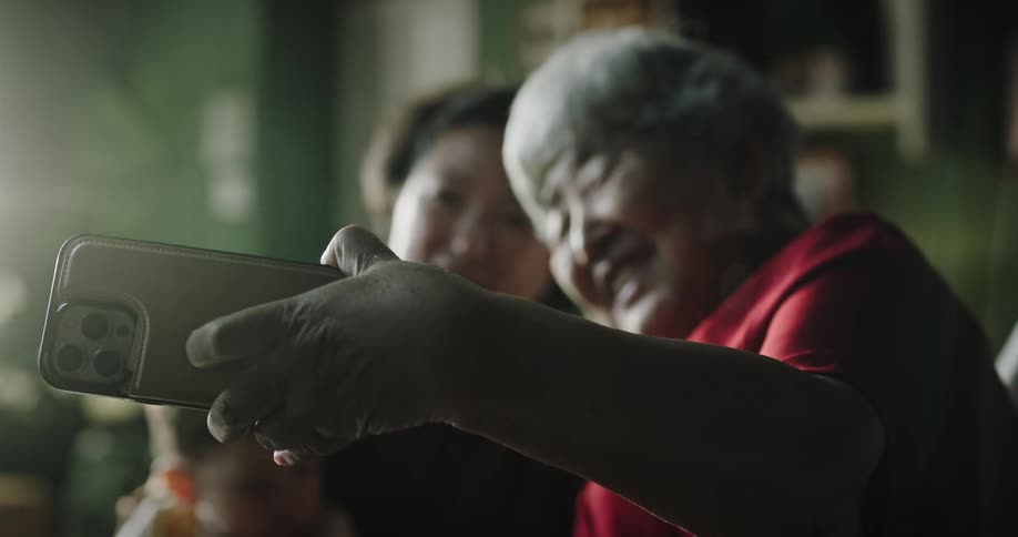 Grandmother taking a photo with her daughter and grandson in a selfie