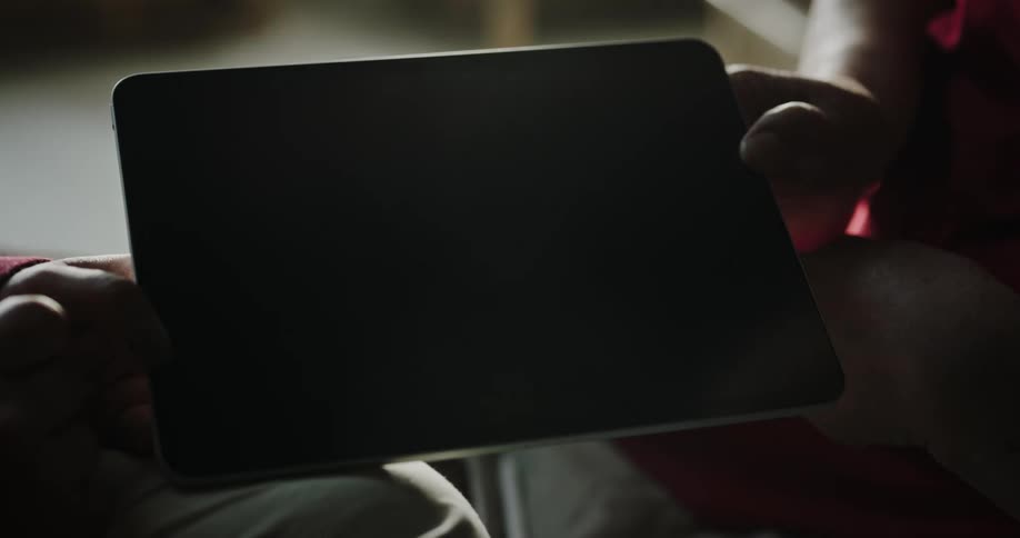A person swipes the screen of a turned off tablet