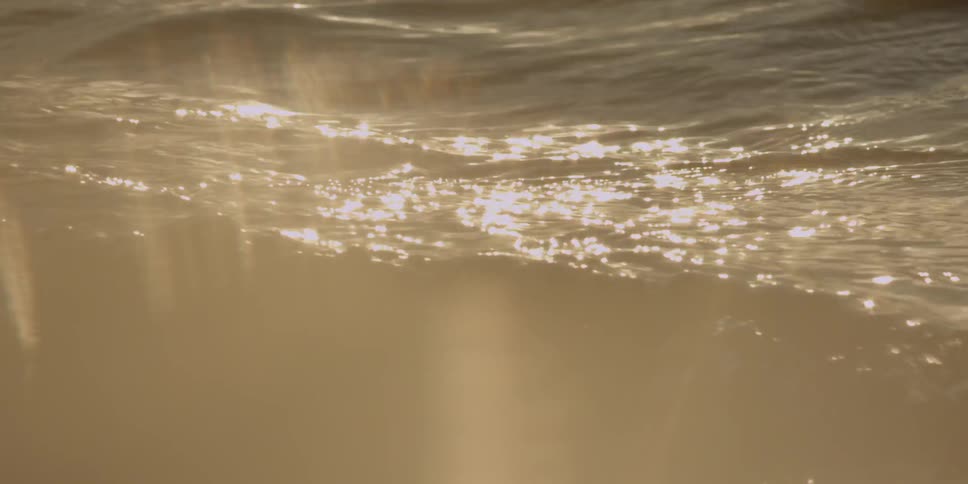 Rays of sun hit rocky water
