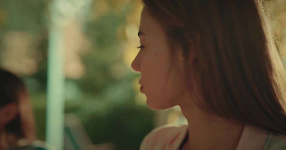 Portrait of a young woman drinking juice from a glass next to her friend