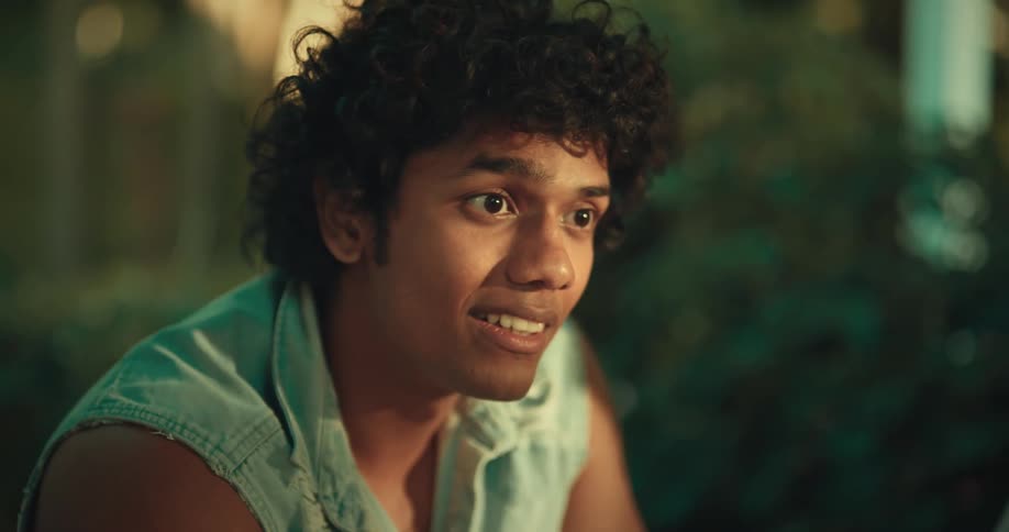 Portrait of a young man sitting at a table with friends playing