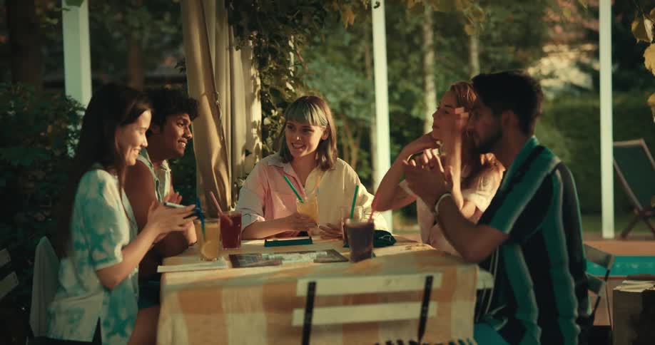 Friends celebrate with drinks at an outdoor table