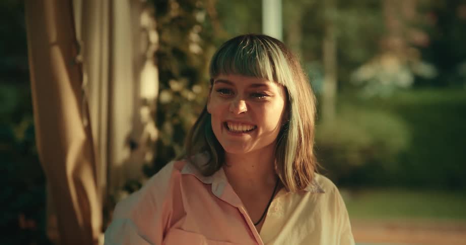 Friends sitting at outdoor table celebrate good news with high fives and touched glasses