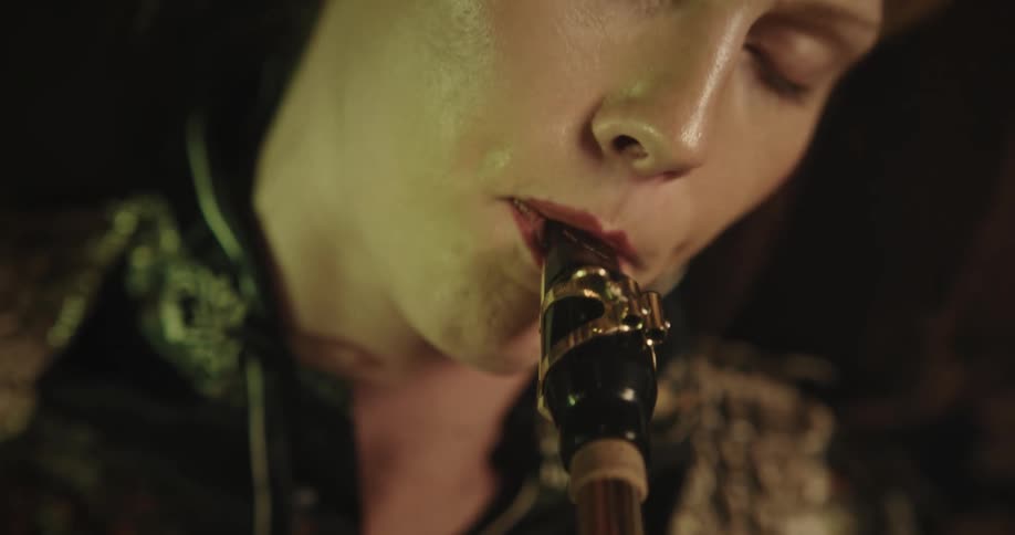Woman lying down with closed eyes playing a trumpet