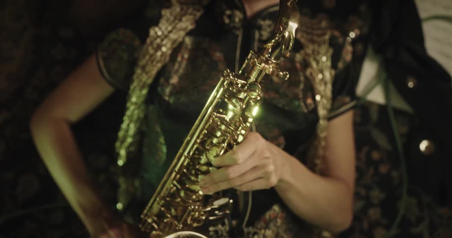 Woman looking at music notes while lying down and then playing a trumpet