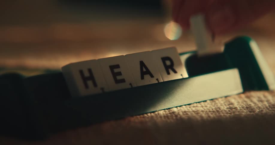A person is playing the board game scrabble