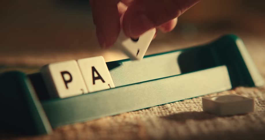 Closeup of a persons hand placing letters to form a phrase