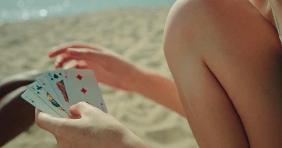 People playing cards on the beach on a hot summer day
