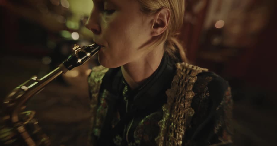A woman playing the saxophone in a music studio