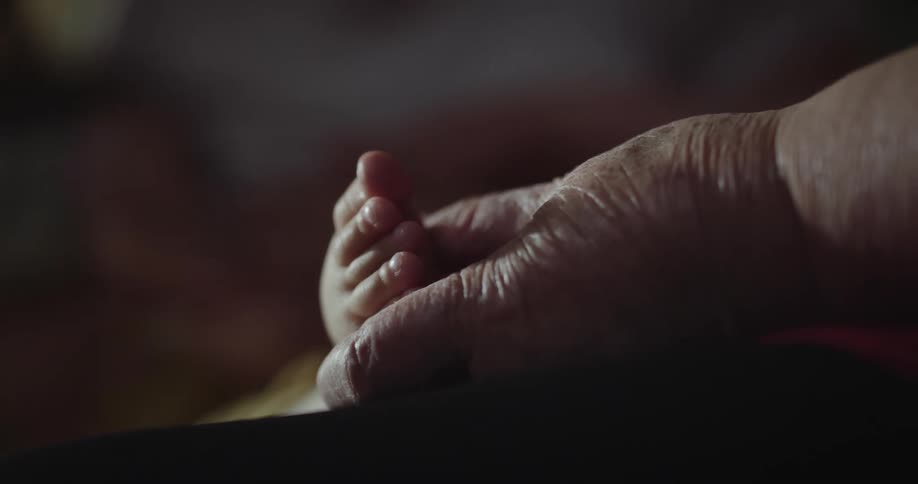 A person holding a babys feet