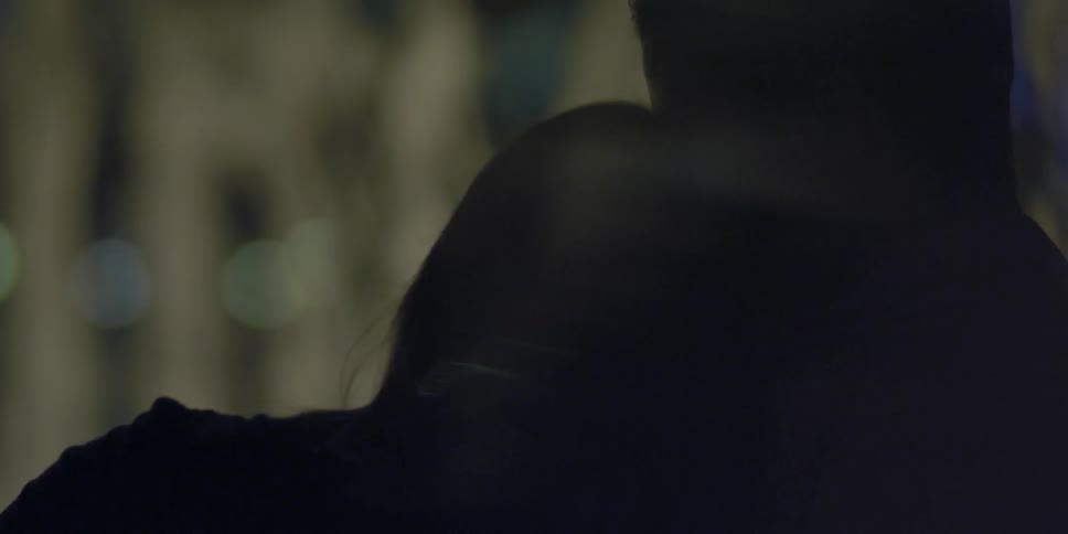 Woman lifts her head from a man's shoulder