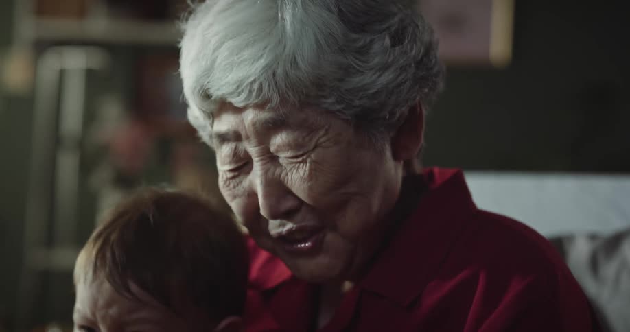 A grandmother holding her crying grandson