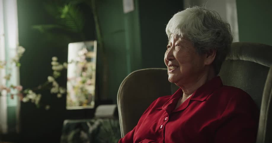 Grandmother sitting in a chair next to her daughter who is holding her granddaughter in her lap