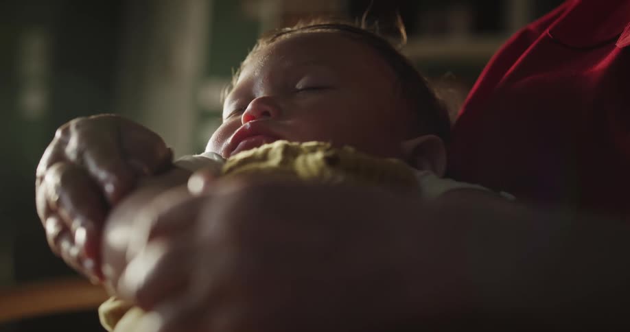 Grandmother holding her sleeping baby grandson on her lap