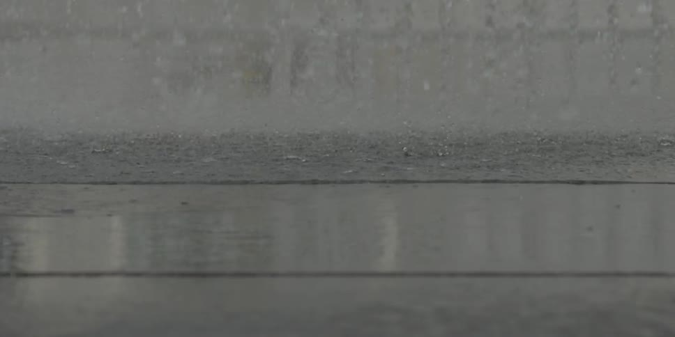 A young girl wearing flip flops plays in spraying water