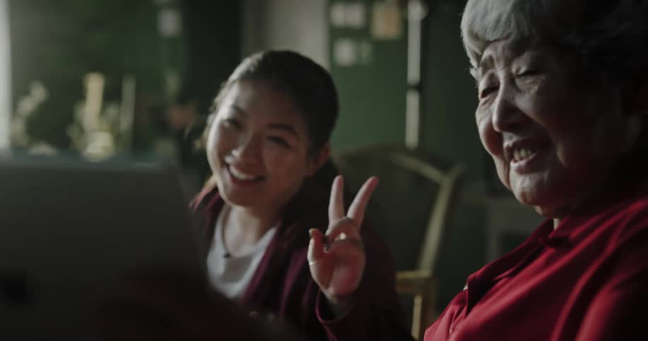 Portrait of the elderly mother taking a selfie with her daughter using a tablet