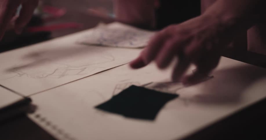 A tailor matches fabric to sketches
