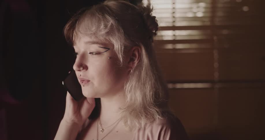 Female teen smiling while talking on phone in a room