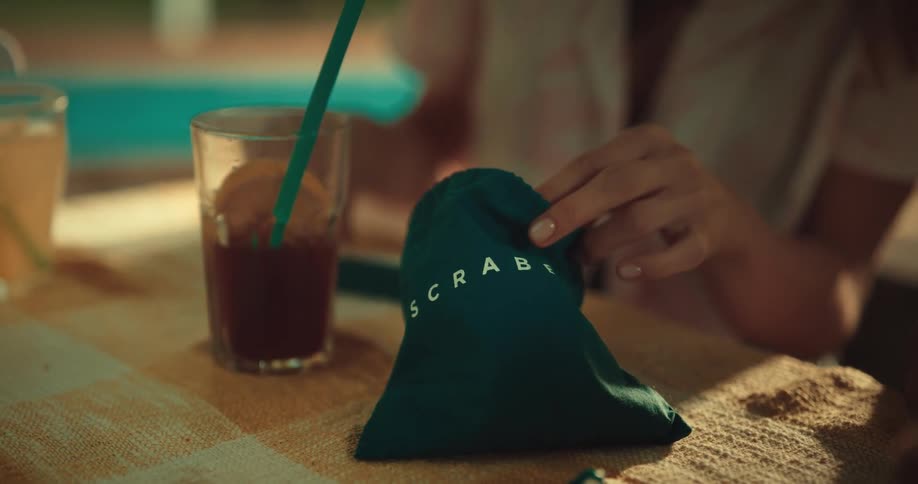 Woman takes scrabble tiles from a bag
