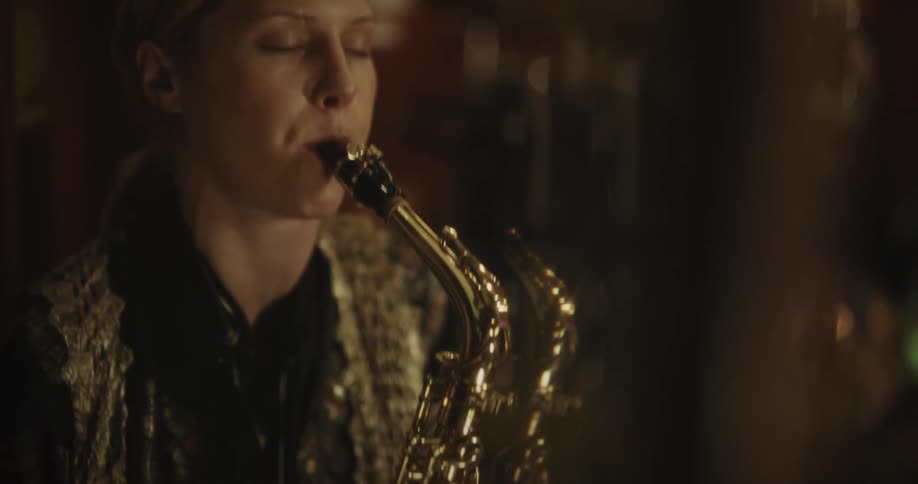 Blonde woman plays saxophone