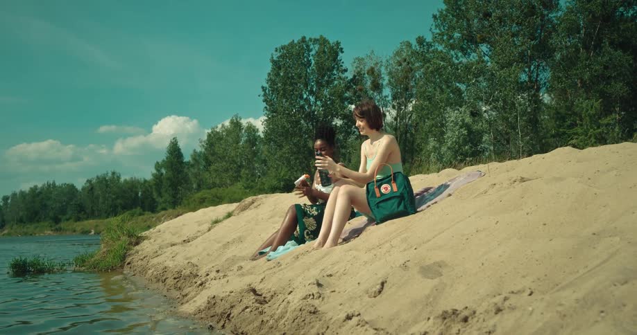 Friends sunbathing by the sea on a sunny day