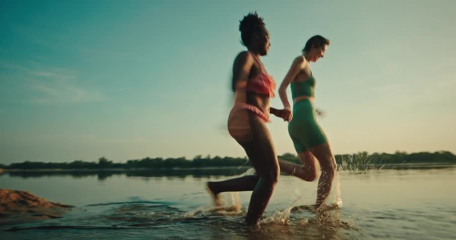 Friends running to get into the water during sunset