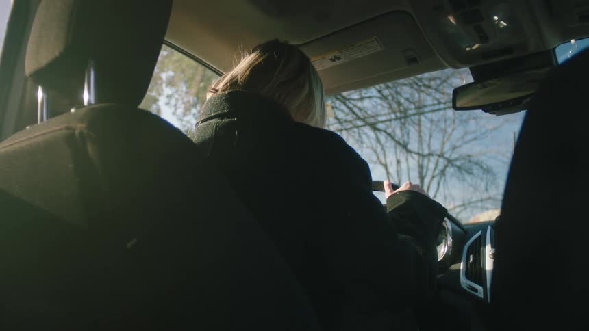 Woman sitting in the car seat and closing the door