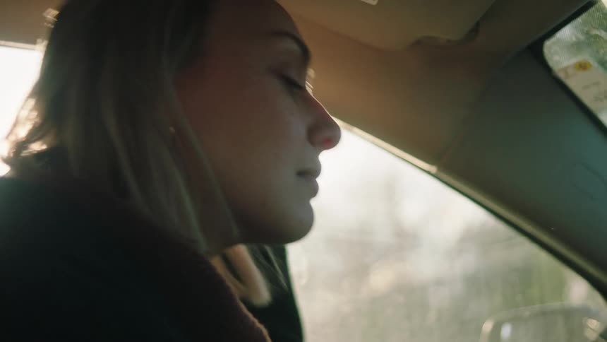 A sad woman crying in the car on a sunny morning