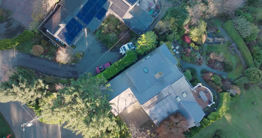 Ascending twist above multiple solar panel arrays installed on a small camper RV and the roofs of two differnet homes