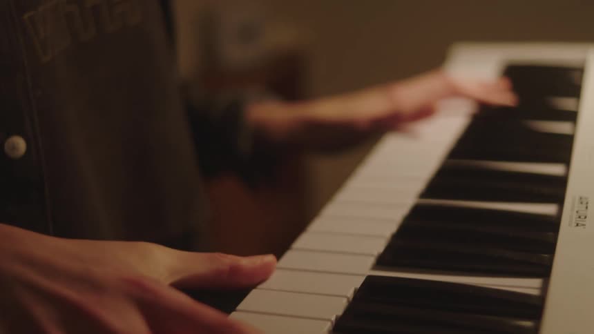 Closeup of a womans hands under a digital piano