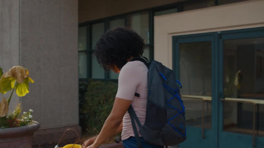 A student leaves the school with her bicycle