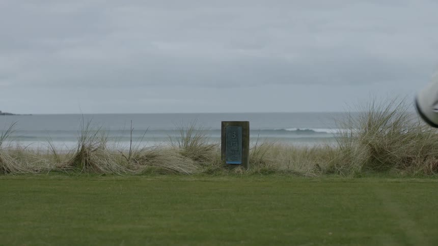 A golf course in front of a deserted beach