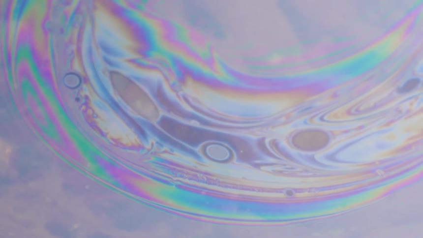 Rainbow colored streaks flow through glowing mixture