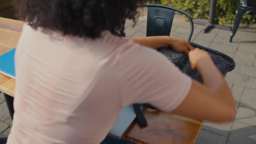 A woman removes her laptop from the bag