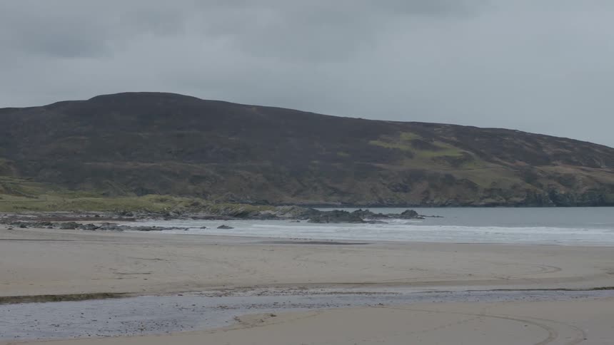 A house near the sea between mountains on a cloudy day