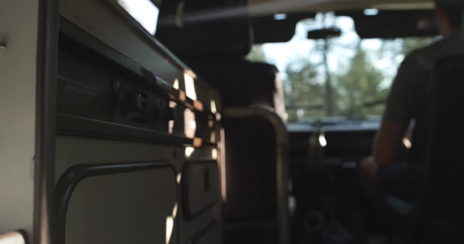 A person drives a motorhome while another person rides in the passenger seat
