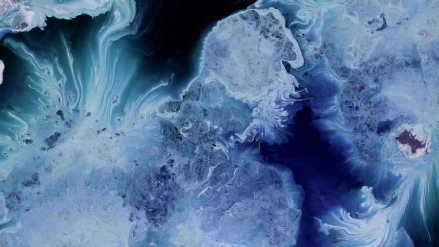 Extreme closeup of abstract blue and white liquids in motion in slow motion