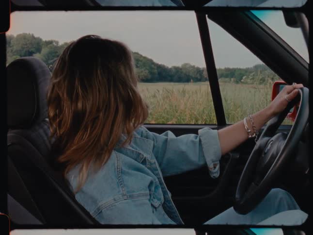 A woman sitting in the car admiring the countryside
