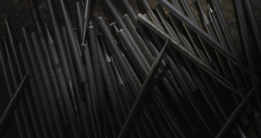 Shadows fall over metal pipes that lay on the floor