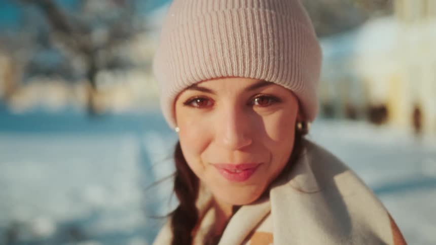 Portrait of a woman with a cap giving a smile in a snowycovered space
