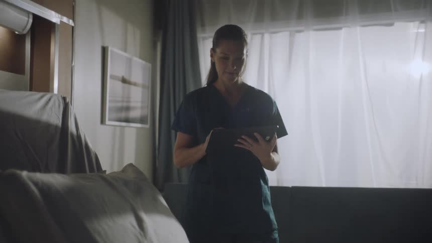 Nurse using a tablet in an empty hospital room